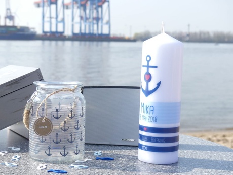 Glas und Kerze mit maritimen Motiven vor Elbe